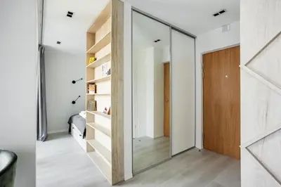 a pivot door in a hallway with a mirror at Brand New Smart House City Center in Vilnius