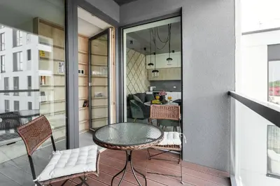 a balcony with a table and chairs and a dining room at Brand New Smart House City Center in Vilnius
