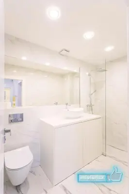 a white bathroom with a toilet and a sink at Mieterlux White in Vilnius