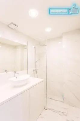 a white bathroom with a sink and a shower at Mieterlux White in Vilnius