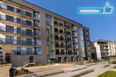 an apartment building with a sign on the side of it at Mieterlux White in Vilnius