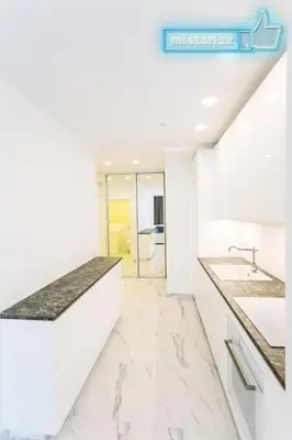 a kitchen with white counters and marble counter tops at Mieterlux White in Vilnius