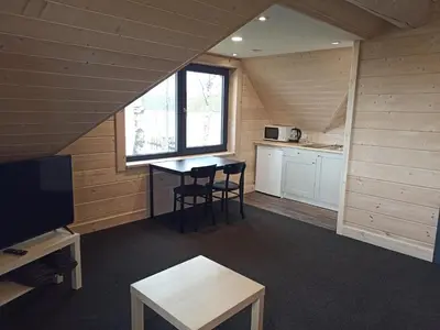 a small room with a table and a kitchen at Du Horizontai in Molėtai