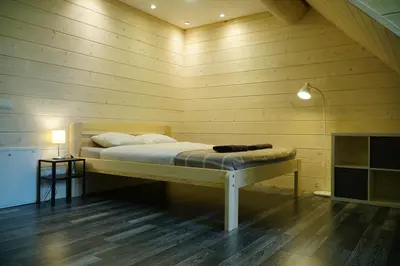 a bedroom with a bed in a wooden wall at Du Horizontai in Molėtai