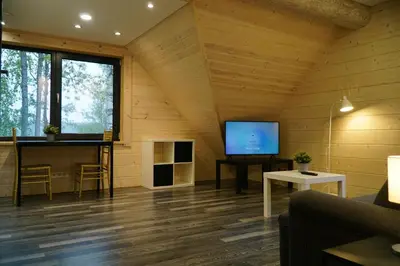 a living room with a flat screen tv in a cabin at Du Horizontai in Molėtai