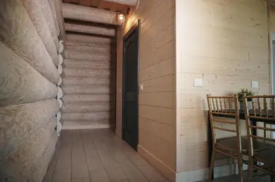 a hallway with a door and a table and a chair at Du Horizontai in Molėtai