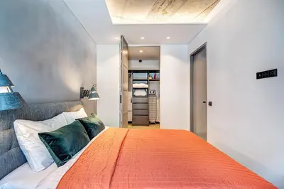 a bedroom with a large bed with an orange blanket at HaPPy Inn Presidential, Self check-in, Parking in the underground garage in Vilnius
