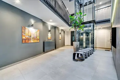 a lobby with a row of stools and a plant at HaPPy Inn Presidential, Self check-in, Parking in the underground garage in Vilnius