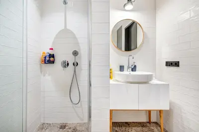 a bathroom with a shower with a sink and a mirror at HaPPy Inn Presidential, Self check-in, Parking in the underground garage in Vilnius