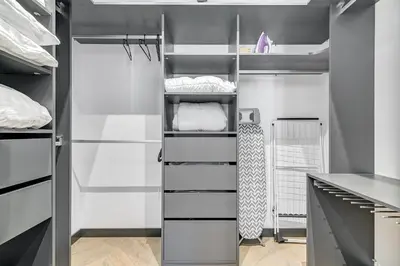 a walk in closet with white and black shelves at HaPPy Inn Presidential, Self check-in, Parking in the underground garage in Vilnius