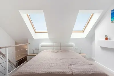 a white bedroom with two windows and a bed at Luxurious Kaunas Basilica Apartment in Old Town by Urban Rent in Kaunas