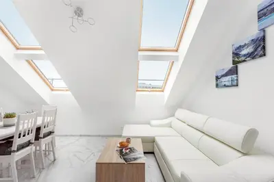 a living room with a white couch and a table at Luxurious Kaunas Basilica Apartment in Old Town by Urban Rent in Kaunas