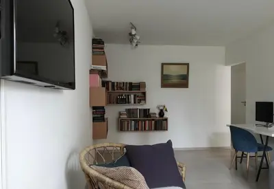 a living room with a couch and a tv on a wall at Homely apartment in Kėdainiai in Kėdainiai