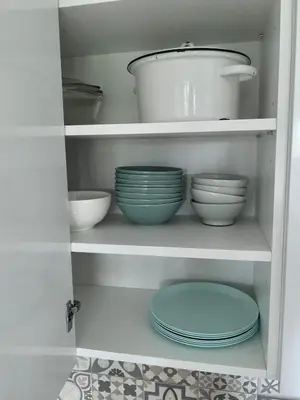a cabinet filled with bowls and plates in a kitchen at Homely apartment in Kėdainiai in Kėdainiai