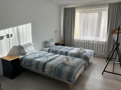 a bedroom with two beds and a window at Homely apartment in Kėdainiai in Kėdainiai