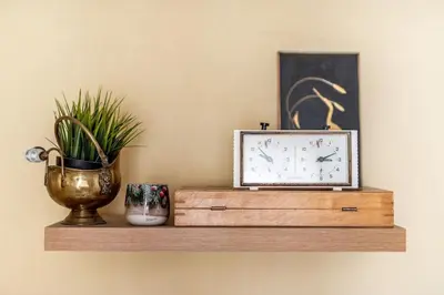 a clock and a vase on a wooden shelf at Angel House Vilnius, 6 in Vilnius