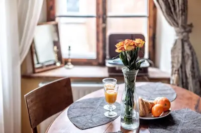 a table with a vase of flowers and bread and orange juice at Angel House Vilnius, 6 in Vilnius