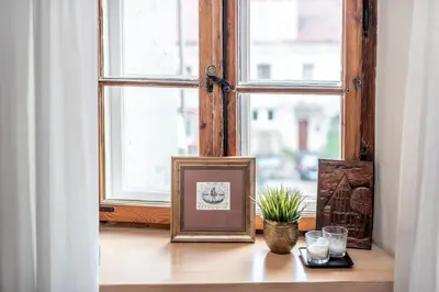 a window sill with a picture and glasses on a table at Angel House Vilnius, 6 in Vilnius