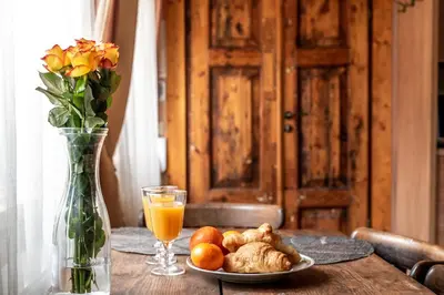 a table with a plate of food and a glass of orange juice at Angel House Vilnius, 5 in Vilnius