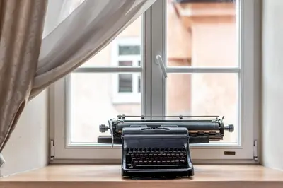 a typewriter sitting on a table in front of a window at Angel House Vilnius, 5 in Vilnius