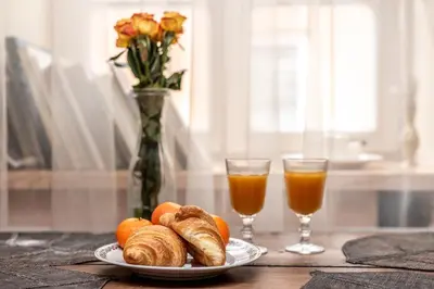a table with a plate of croissants and two glasses of orange juice at Angel House Vilnius, 5 in Vilnius
