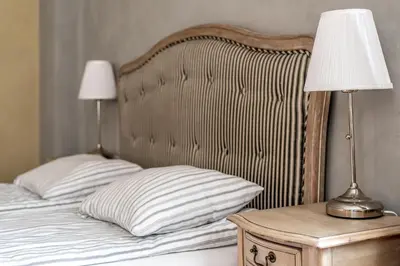 a bed with a wooden headboard and a lamp on a table at Angel House Vilnius, 5 in Vilnius