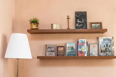 a shelf with books and photos on a wall at Angel House Vilnius, 5 in Vilnius