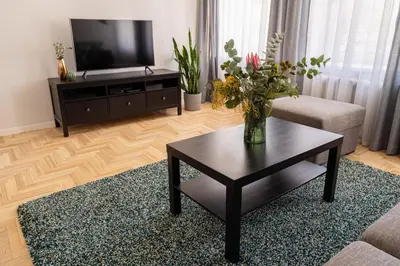 a living room with a vase of flowers on a coffee table at Lovely apartment in the city center in Kaunas