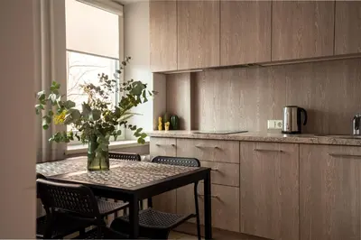 a kitchen with a table with chairs and a vase with flowers at Lovely apartment in the city center in Kaunas