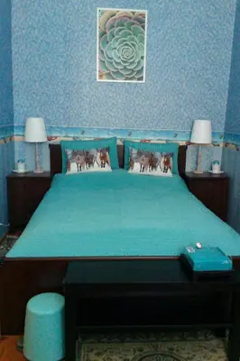 a blue bedroom with a bed with a blue bedspread at Saint Stephen Old Town Apartment in Vilnius