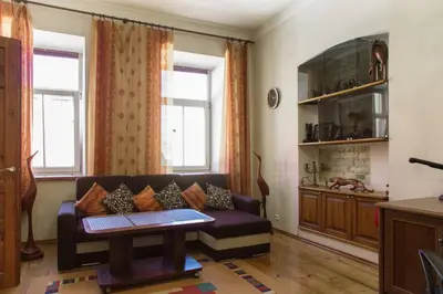 a living room with a couch and two windows at Saint Stephen Old Town Apartment in Vilnius
