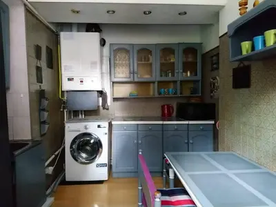a kitchen with blue cabinets and a washing machine at Saint Stephen Old Town Apartment in Vilnius