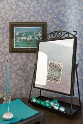 a mirror on a table with a picture and a candle at Saint Stephen Old Town Apartment in Vilnius