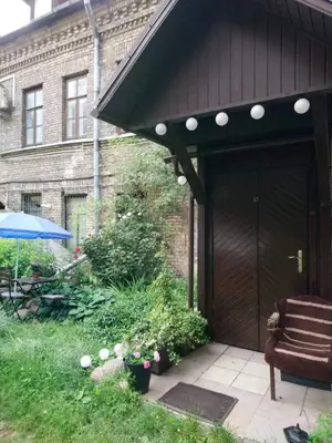 a brown house with a wooden door and a chair at Saint Stephen Old Town Apartment in Vilnius