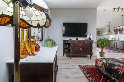 a living room with a table and a tv at Heritage Boutique 'Green Hill' in Kaunas