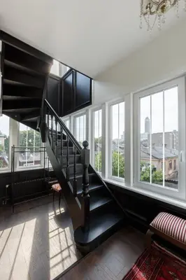 a staircase in a living room with windows at Heritage Boutique 'Green Hill' in Kaunas