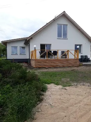a house with a large deck with chairs on it at Kaimo Vila “Padange” in Kančėnai