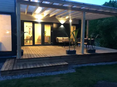 a wooden deck with a pergola in a backyard at Eden House in Druskininkai