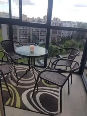 a table and chairs on a balcony with a view at Klaipėdos 99 Apartamentai in Panevėžys
