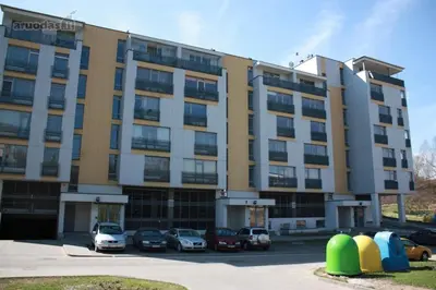 a large building with cars parked in a parking lot at Kaminkelio apartment 44 in Vilnius