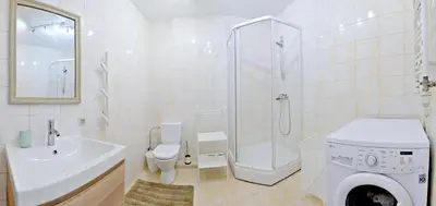 a bathroom with a shower toilet and a washing machine at Kaminkelio apartment 44 in Vilnius