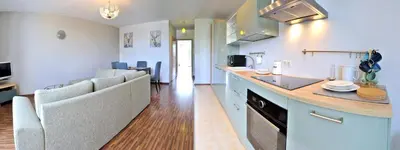 a kitchen and living room with a counter and chairs at Kaminkelio apartment 44 in Vilnius