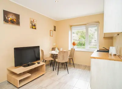 a kitchen and dining room with a television and a table at Chill&Go Premium in Kaunas