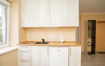 a kitchen with white cabinets and a sink at Chill&Go Premium in Kaunas