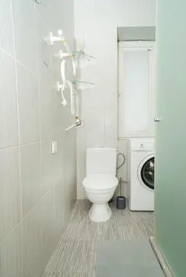 a bathroom with a toilet and a washing machine at Chill&Go Premium in Kaunas