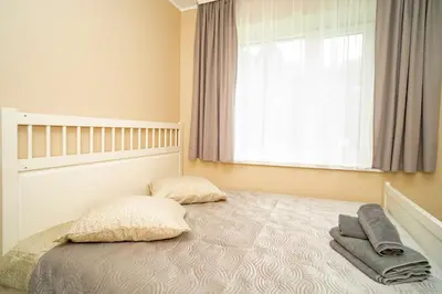 a bedroom with a bed with two pillows and a window at Chill&Go Premium in Kaunas