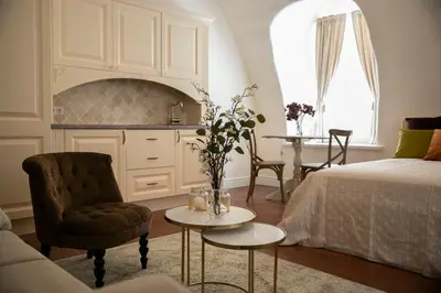 a living room with a bed and a table and a chair at Heart of OLD TOWN - St. Ann apartment in Vilnius