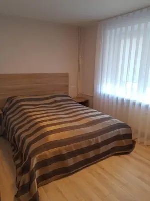 a bedroom with a bed with a striped blanket on it at Vilniaus 123 in Šiauliai