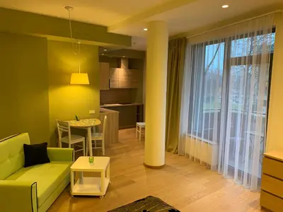 a living room with a couch and a table at Brolių studija in Druskininkai