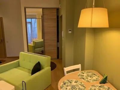 a living room with a couch and a table at Brolių studija in Druskininkai
